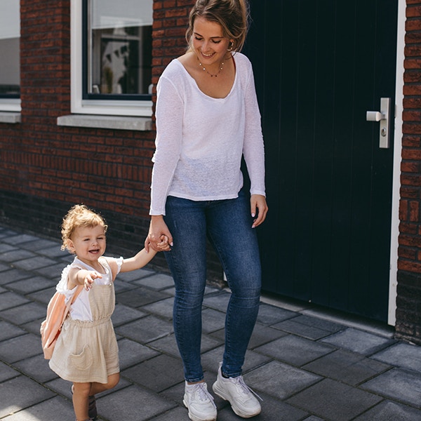 Babysitter walks hand in hand with her babysitter and smiles